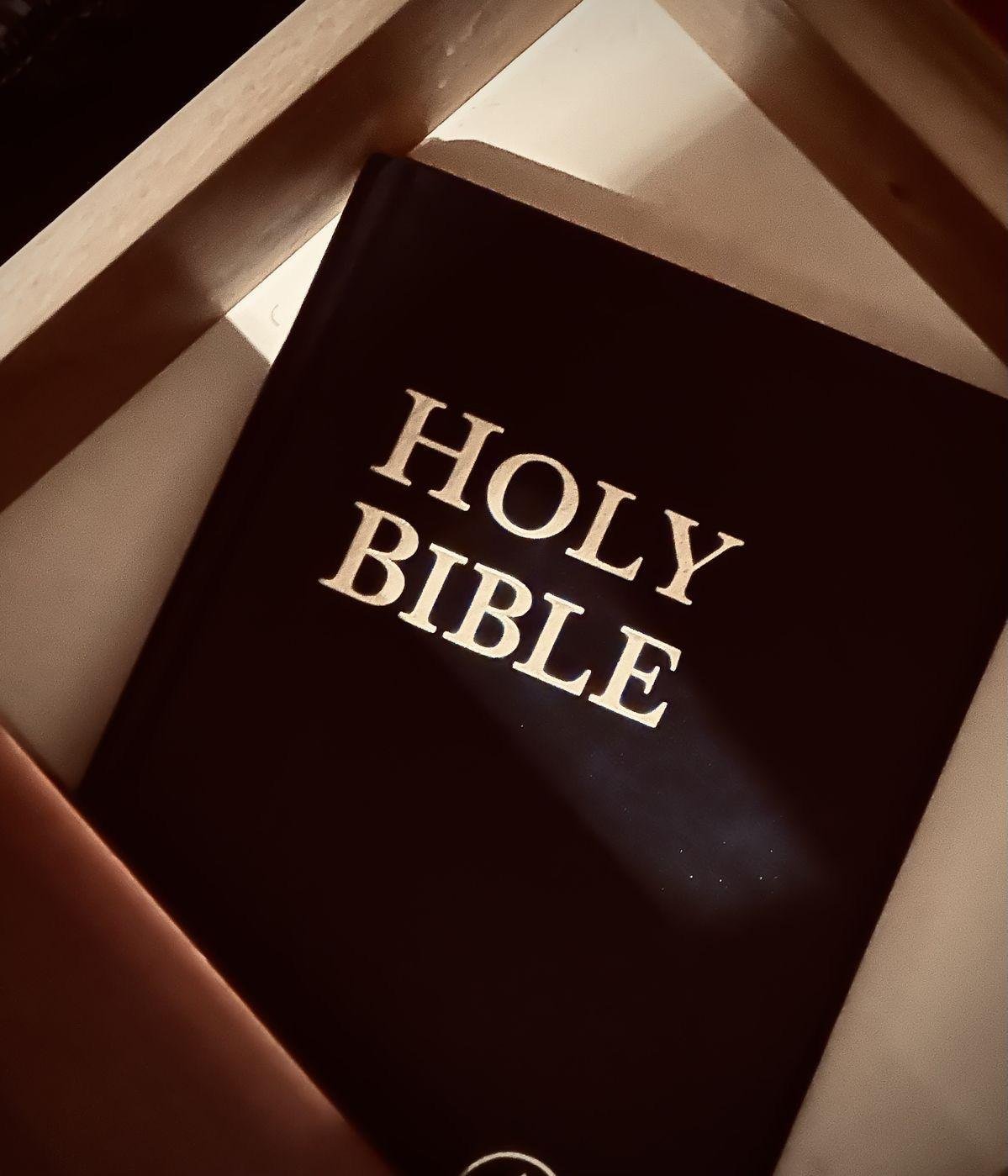 Schwarze Bibel mit goldener Prägung im warmen Licht