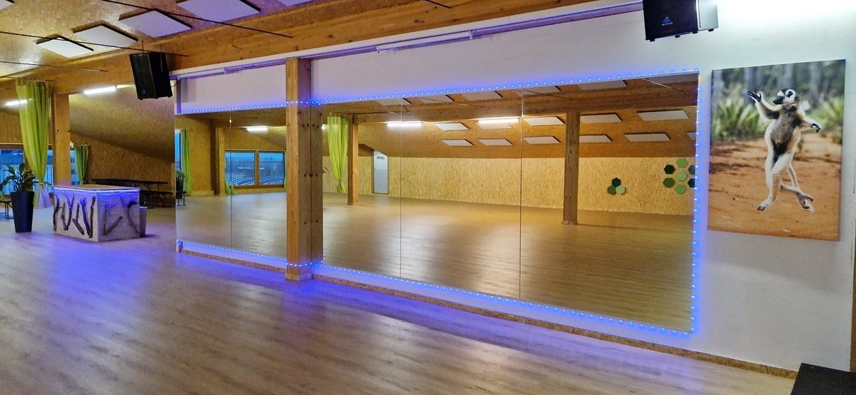 Saal mit Spiegelwand und warmem Holzboden